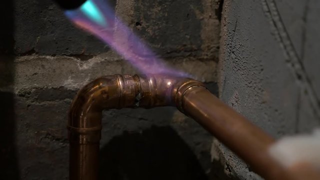 DIY renovation blow torch to braze solder on copper water pipe elbow fittings England May 2017
