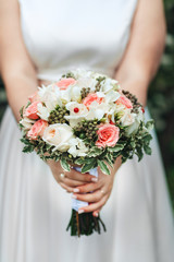 Beauty wedding bouquet in bride's hands, close - up