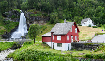 Fototapeta na wymiar Red house near Steinsdalsfossen waterfall