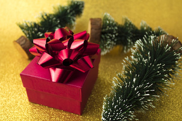 red gift box with xmas tree on gold glitter background