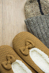 Fototapeta na wymiar Handmade Warm Knitted Socks From Coarse Wool Yarn Fluffy Fur Slippers on Wood Background. Winter Autumn Eco Fashion Cloths Kinfolk Style. Natural Materials.