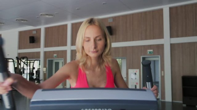 Beautiful sporty woman is exercising at the gym centre.