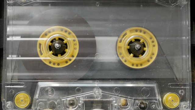 Retro cassette in casettophone close-up footage - Rotation of audio tape player supply spindle