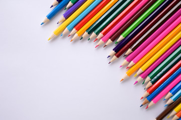Colored crayons background. Many different colored pencils on white background