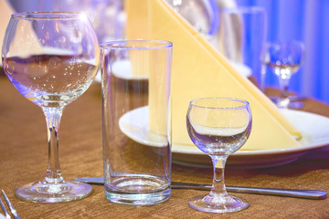 The table in the restaurant. On the table there are empty wine glasses, napkins and a plate