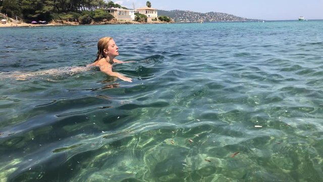 Swimming in crystal clear water footage -Caucasian female on in the sea French riviera