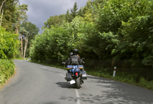 Young couple of motorcyclists riding on forest road. Active lifestyle. Europe trip.