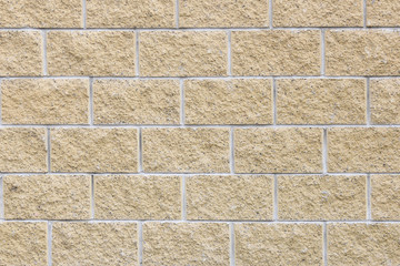 Wall of yellow decorative stone bricks. Building background. 