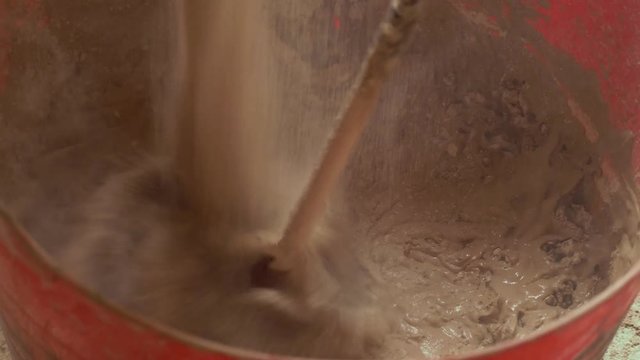 Mixing gypsum plaster powder with electric whisk paddle mixer construction England April 2017