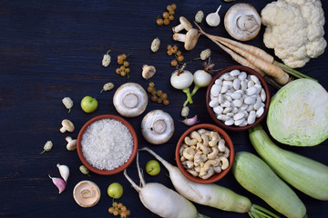 White vegetables and fruits on a wooden background - currant, cauliflower, champignons, radish, parsley, mushrooms, garlic. Onion, cabbage, mulberry, rice cashew beans Vegetarian food Flat lay