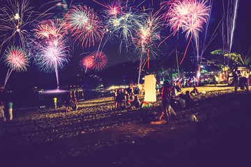 Background festive New Year with fireworks and bokeh. New Year fireworks on the beach.