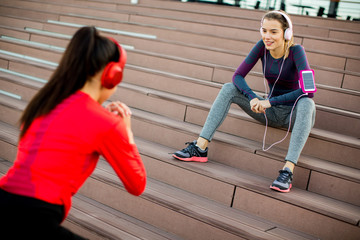 Obraz premium Attractive woman exercising with a personal trainer outside in the morning