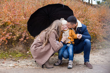 family autumn in the Park in the rain umbrella