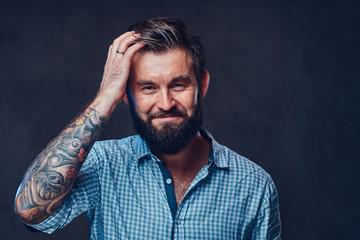 A man with tattoo on arm dressed in a shirt.