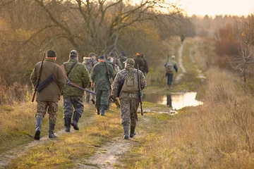 Rolgordijnen group of hunters in forest © gsshot