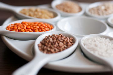 Cereals in a white dish on a dark wooden background. Close-up with soft focus.