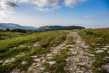 Stone road at mountain plateau, dramatic mountain landscape