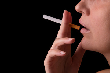 Girl with a cigarette in her hand on a black background. Smoking girl