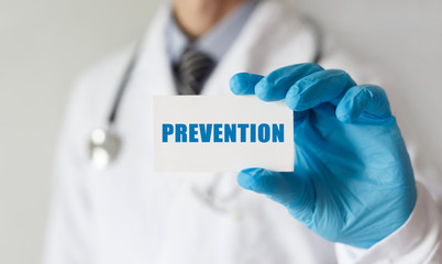 Doctor holding a card with text PREVENTION,medical concept