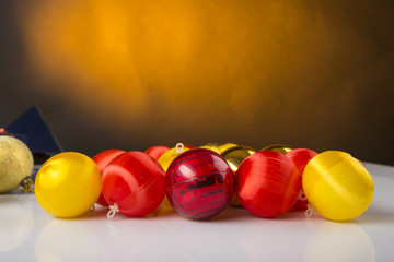 Palle di natale colorate sfuse su superficie  bianca e sfondo giallo