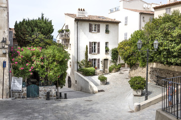 France, Saint-Tropez, French Riviera, Cote d'Azur: Street scene of quite place in the old town with white house, green trees.