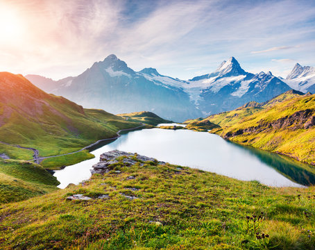 Colorful summer sunrise on Bachalpsee lake with Schreckhorn and Wetterhorn peacks on background.
