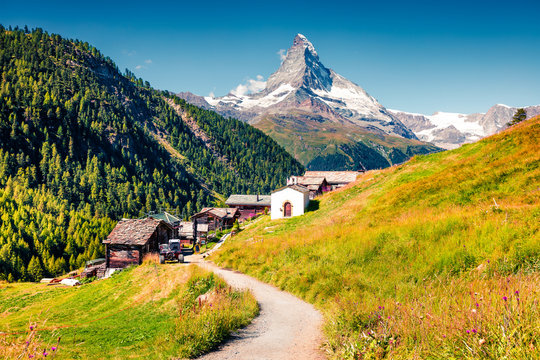 Sunny summer morning in Zermatt village with Matterhorn (Monte Cervino, Mont Cervin) peak on backgroud.