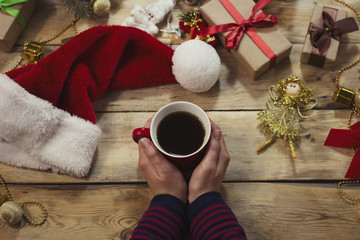 Woman's hands in a sweater hold a cup of coffee. New Year and Christmas gifts. Winter concept. Flat, top view