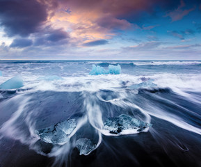 Fototapeta na wymiar Blocks of ice washed by the waves on Jokulsarlon beach