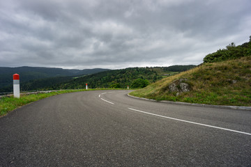 France - Route de cretes at curved point with guardrail between forest