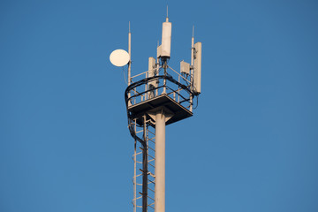 the antennas on the cell tower on blue sky background