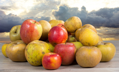 red and yellow organic apples on wooden table