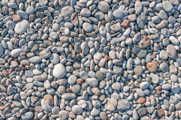 Detail of stone beach in greece made of small pebble stone texture