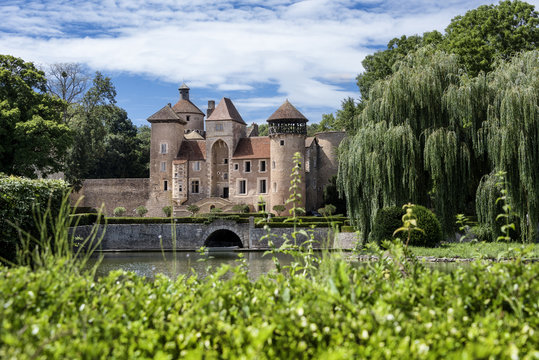 France, Department Saone-et-Loire, Sercy: Front view of an old castle (chateau) surrounded by park and water