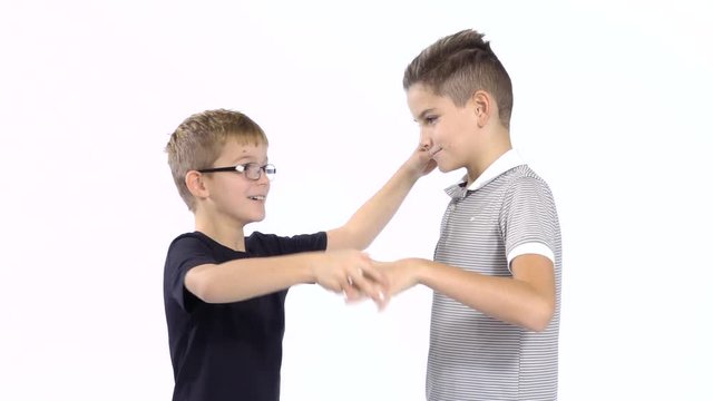 Two boys plays in paper, scissors, rock at white background