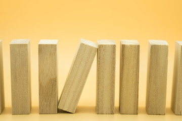 Leadership and risk management concept. One wooden block stopping collapse the effect of wooden blocks with green nature as background