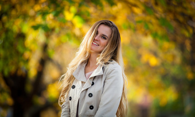 Cheerful woman walking in the city under colorful autumn trees 2