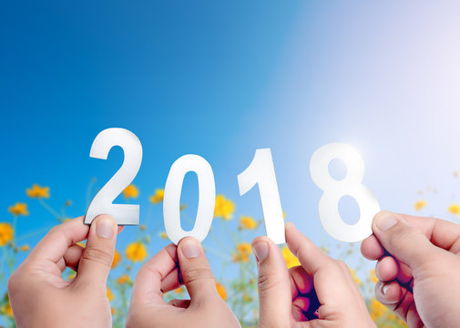 Happy new year concept of 2018,Hands holding Metal words of 2018 on flowers over blue sky