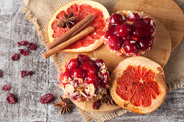 Fresh fruit tart with berries jam decorated with cranberry, mint on wooden rustic background wit a cup of tea. Desert. Morning healthy breakfast and evening dinner.