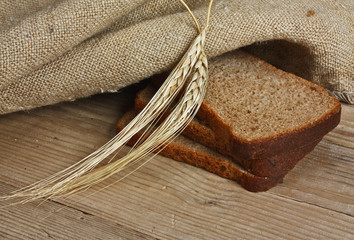 slices of rye bread and ears of corn on a wooden table