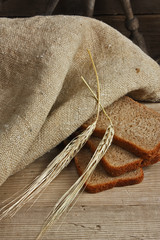 slices of rye bread and ears of corn on a wooden table