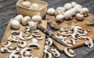 Fresh white mushrooms on a wooden background.Champignons de Paris cut in pieces.