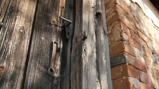 Tilting on rotten wooden planks and rusty lock details  footage - Abandoned house doors close-up slow tilt