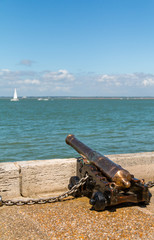 A brass starting cannon looks out over the Solent during a sunny Cowes week on the Isle of Wight