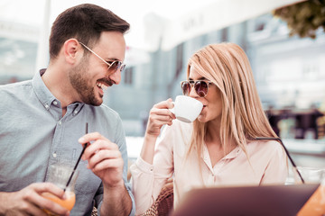 Pretty young businesswoman drinking coffee at the meeting.