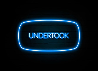 Undertook  - colorful Neon Sign on brickwall
