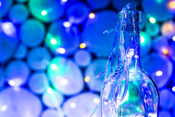 a bottle with a garland and lights inside - a Christmas decoration. background