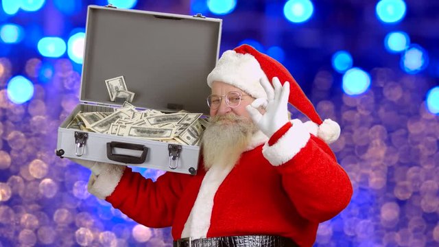 Santa Claus, suitcase with money. Santa showing ok gesture.