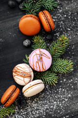 Oranges, macaroons, chocolate and fir branches on a black background. flat lay,  top view,