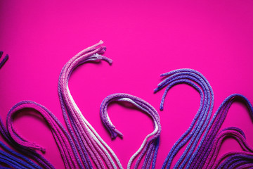 colorful sewing threads on pink background